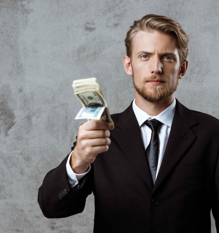 young-successful-businessman-suit-holding-money